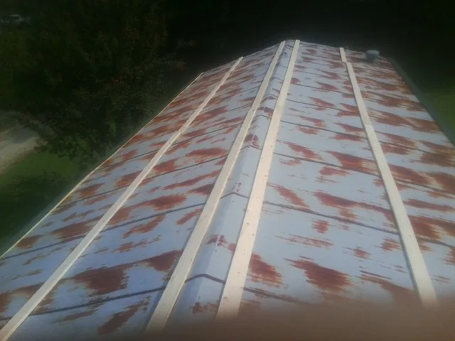 Rusted metal roof panels with new wood purlins before replacement — Storm Damage Roof Repair in Gastonia by Roofing Brothers