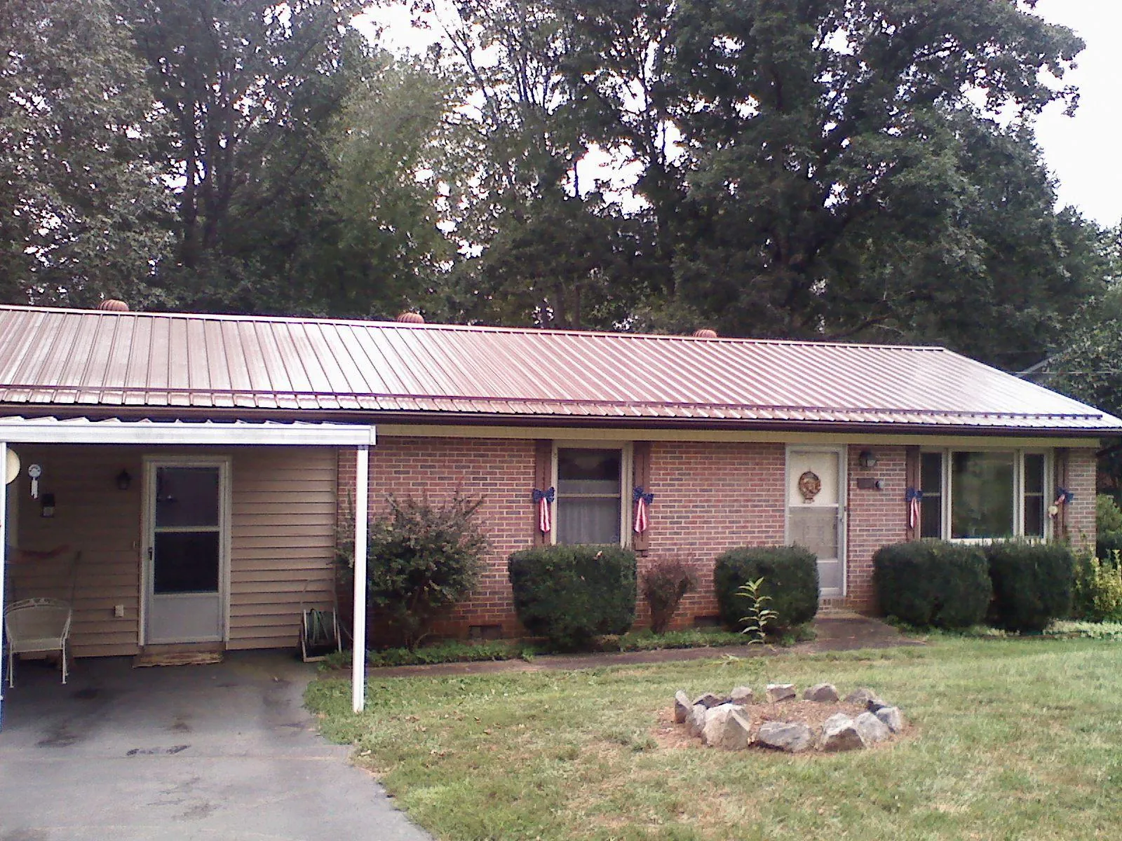 Bronze metal roof and carport on a brick ranch home — Roof Repair work by our crew in Gastonia