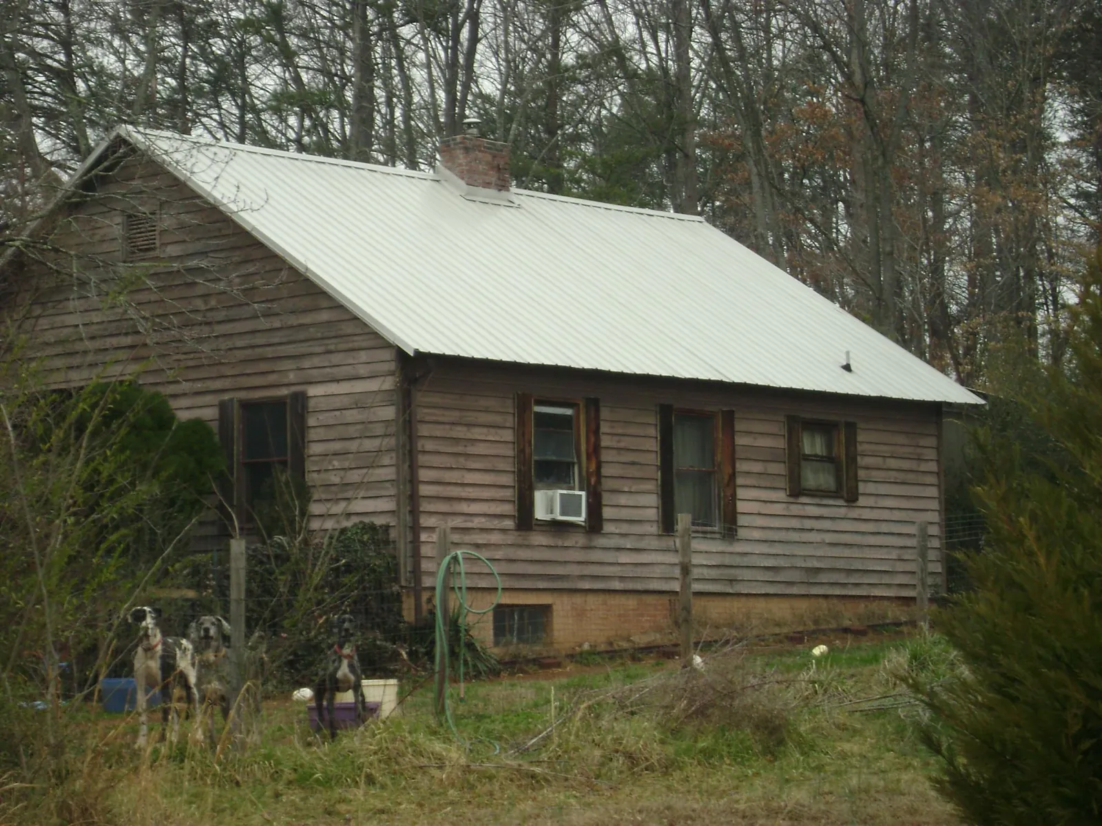 White metal roof on an old wood sided farmhouse, from a Metal Roof Installation job in Gastonia